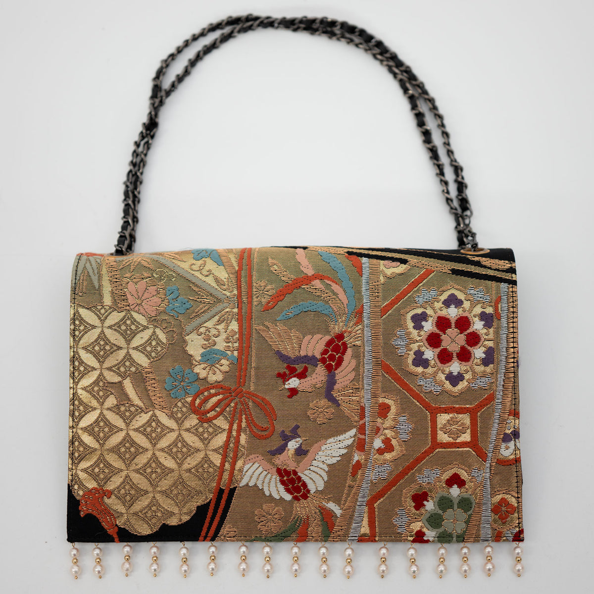 A clutch bag of supreme elegance, adorned with snow ring motifs, dancing flowers, and Akoya pearls.